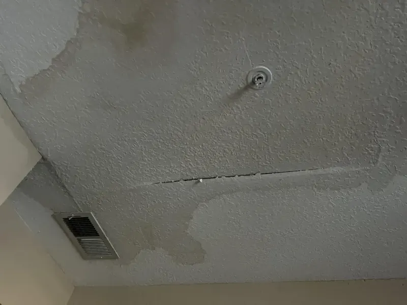 Water-stained ceiling with a crack from a leak in the apartment above in Elmhurst, NY